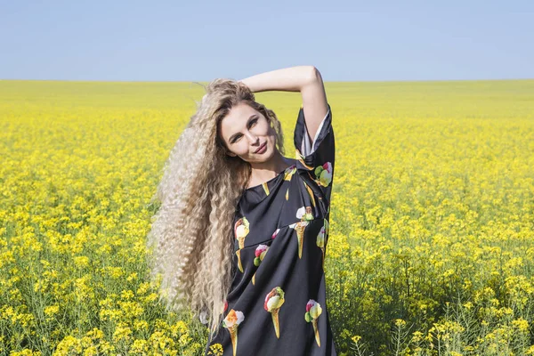 Portrait of a girl in yellow blooming field. — Stock Photo, Image