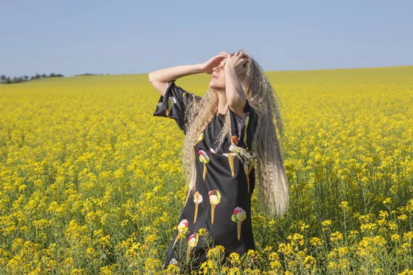 Letnie upały. Dziewczyna pozuje w żółtym polu kwitnący. — Zdjęcie stockowe