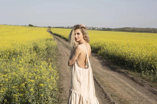 Sexy back of a curly woman in a narutal landscape. — Stock Photo, Image