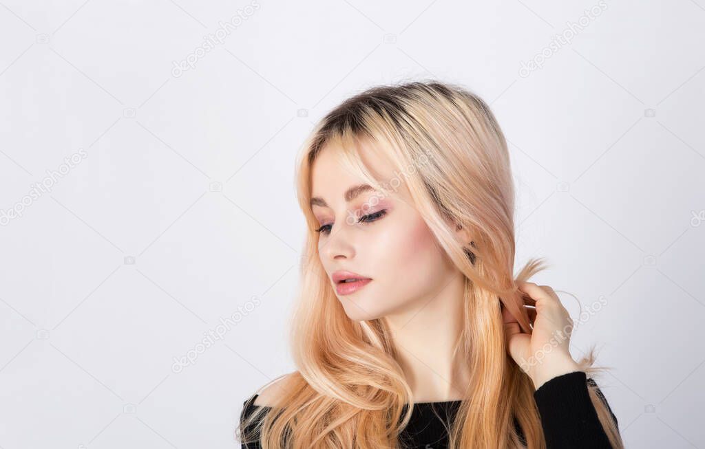 Portrait of a nice and cute blonde model with natural and soft makeup. Space left.