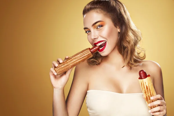Closeup portrait. Beautiful blond young woman having fun eating french hot dog on Oktoberfest holiday. — Stock Photo, Image