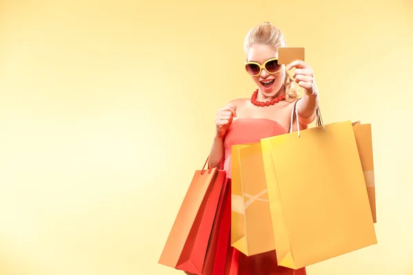 Shopping donna in possesso di borse a colori e mostrando carta di vendita . — Foto Stock