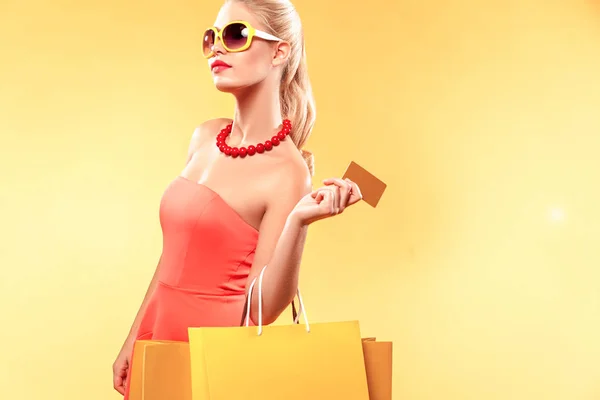 Shopping donna in possesso di borse a colori e mostrando carta di vendita . — Foto Stock