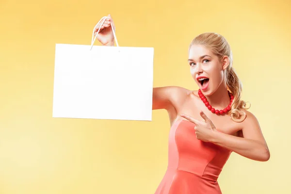 販売。若い笑顔の女性は、黒の金曜日休日のショッピング バッグを示します。コピー スペースと黄色の背景の女の子 — ストック写真
