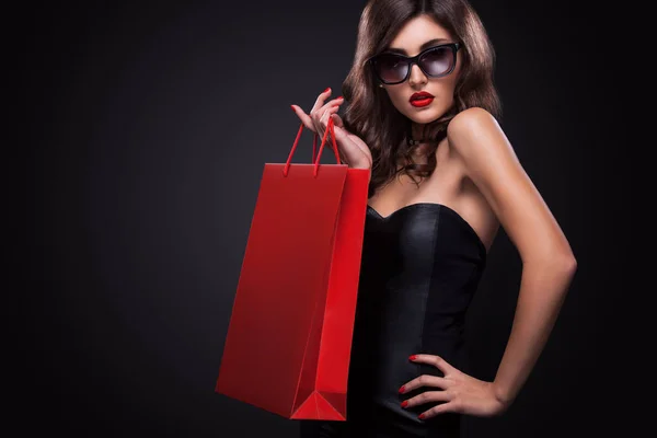 Shopping-Frau mit roter Tasche isoliert auf dunklem Hintergrund in schwarzem Freitag Urlaub — Stockfoto