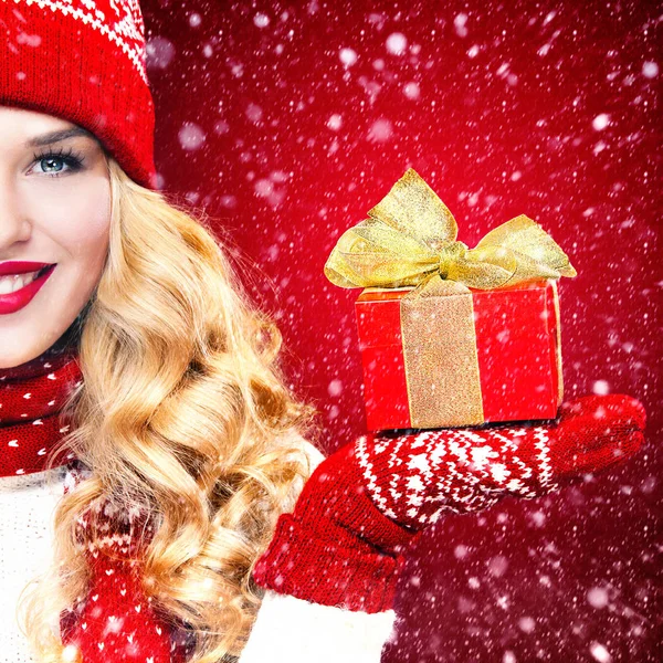Mulher loira bonita com presente de caixa de Natal no fundo vermelho . — Fotografia de Stock
