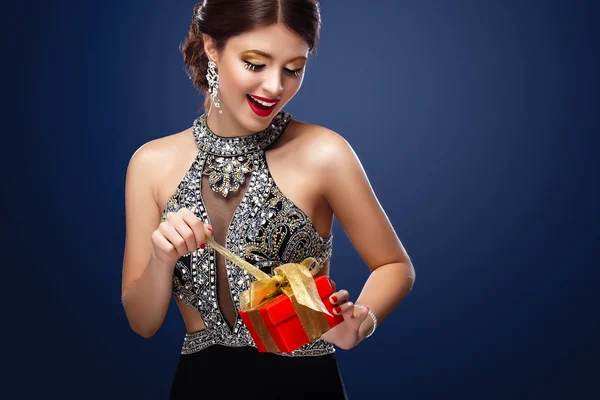 Новый год, Рождество, День Святого Валентина, День рождения, люди и праздники концепция - улыбающаяся женщина в платье с подарочной коробкой на фоне огней. 2017 — стоковое фото