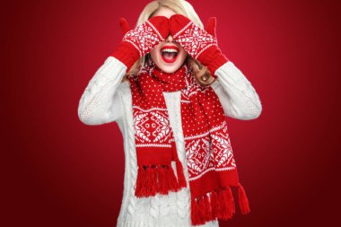 Noel aşınma beklemek hediyeleri, kırmızı zemin üzerine izole mutlu gülen sarışın kadın giyinmiş