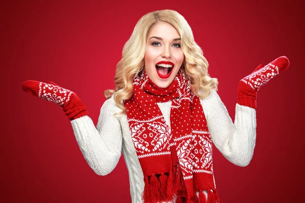 Gelukkig lachen blonde vrouw verkleed in Kerstmis slijtage met duimen, op rode achtergrond hebben kopie ruimte — Stockfoto