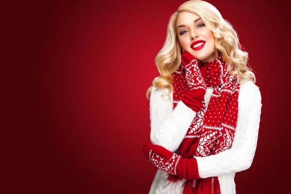 Gelukkig lachen blonde vrouw gekleed in slijtage waitng Kerstcadeaus, geïsoleerd op rode achtergrond met kopie ruimte — Stockfoto