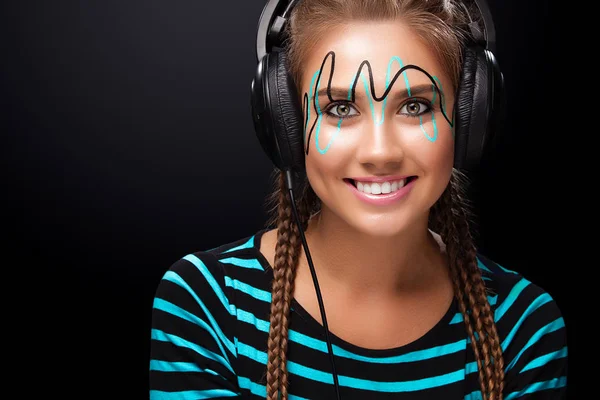 Mujer joven moderna con maquillaje de arte disfruta escuchando música en los auriculares. Emociones positivas, ocio. Copiar espacio . — Foto de Stock