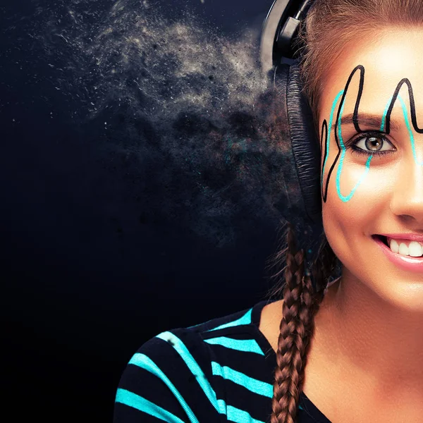 Modern young woman with art makeup enjoys listening to music in headphones. Positive emotions, leisure. Copy space. — Stock Photo, Image