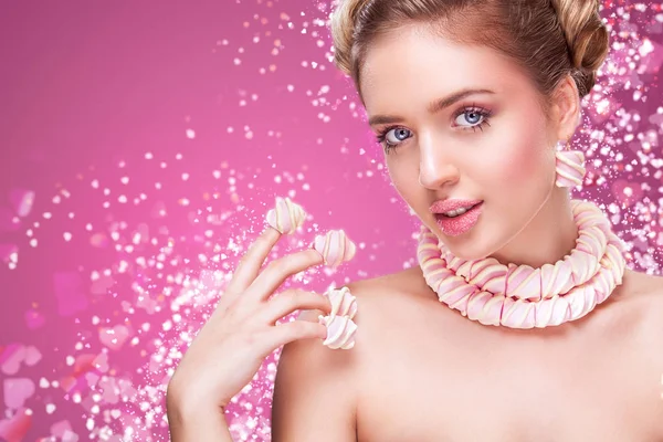 Día de San Valentín. Atractiva mujer con piruleta en la mano sobre fondo rosa — Foto de Stock