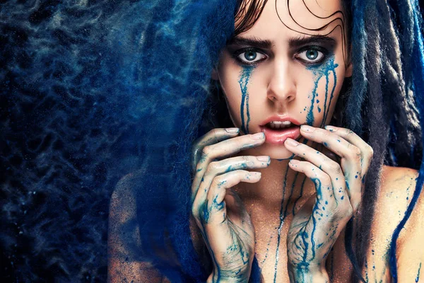 Fashion model girl portrait with colorful paint make up. Sexy woman bright color makeup. Closeup of vogue style lady face, Art design. Blue background — Stock Photo, Image