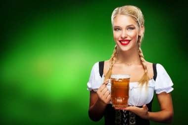 St Patricks Günü. Büyük bira bardağı mavi arka plan üzerinde kopya alanı ile hizmet veren bir geleneksel Bavyera elbise giyen genç seksi Oktoberfest garson,