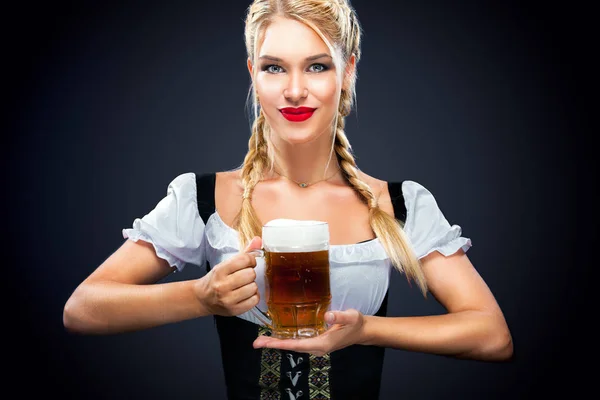 Joven camarera sexy Oktoberfest, con un vestido tradicional bávaro, sirviendo tazas de cerveza grandes en el fondo del bálsamo . —  Fotos de Stock