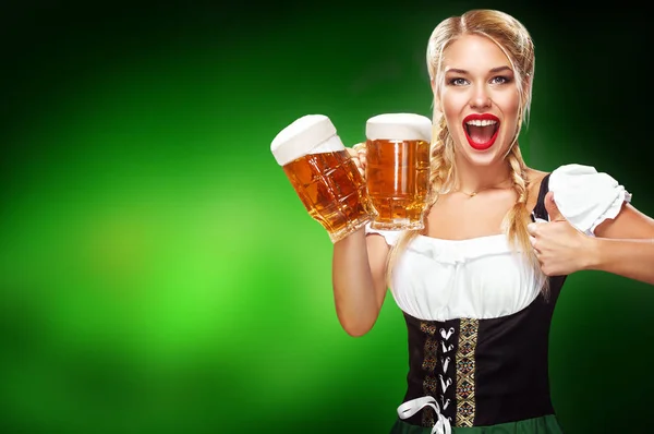 St Patricks Day. Mladá sexy Oktoberfest servírka, tradiční bavorské šatech, s kopií prostor sloužit velké pivní korbele na modrém pozadí — Stock fotografie