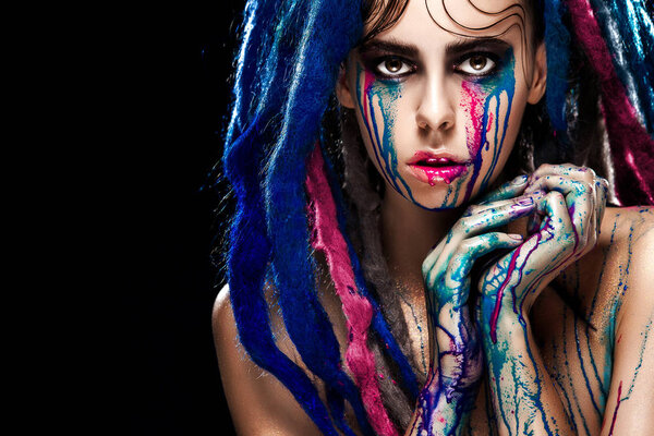 Bodyart model girl portrait with colorful paint make up. Sexy woman bright color makeup. Closeup of vogue style lady face, Art design. Black background