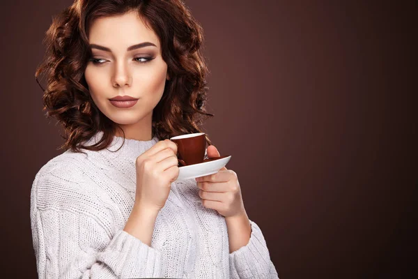 Красивая молодая женщина с чашкой кофе на темном фоне — стоковое фото