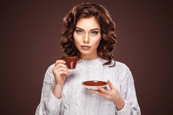 Красивая молодая женщина с чашкой кофе на темном фоне — стоковое фото