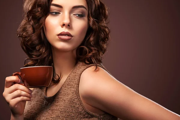 Bela jovem com uma xícara de café no fundo escuro — Fotografia de Stock