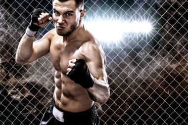 Sporcu muay Taylandlı boksör boks kafes dövüş. Arka plan ile ışık ve duman. Uzay kopyalayın. Spor kavramı.