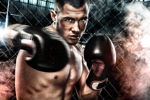 Deportista muay thai boxeador luchando en la jaula de boxeo. Fondo con luces y humo. Copiar espacio. Concepto deportivo . — Foto de Stock
