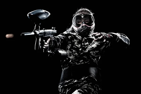 Heavily armed masked paintball soldier isolated on black background. Ad concept. — Stock Photo, Image