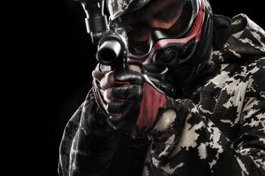 Siyah arka plan üzerine izole ağır silahlı maskeli paintball asker. Reklam kavramı.