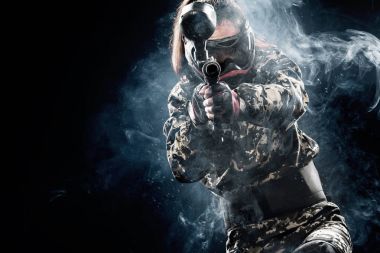 Siyah arka plan üzerine izole ağır silahlı maskeli paintball asker. Reklam kavramı.