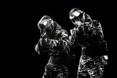 Siyah arka plan üzerine izole ağır silahlı maskeli paintball asker. Reklam kavramı.