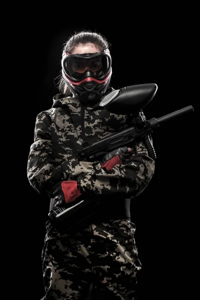 Soldado de paintball enmascarado fuertemente armado aislado sobre fondo negro. Concepto ad . — Foto de Stock