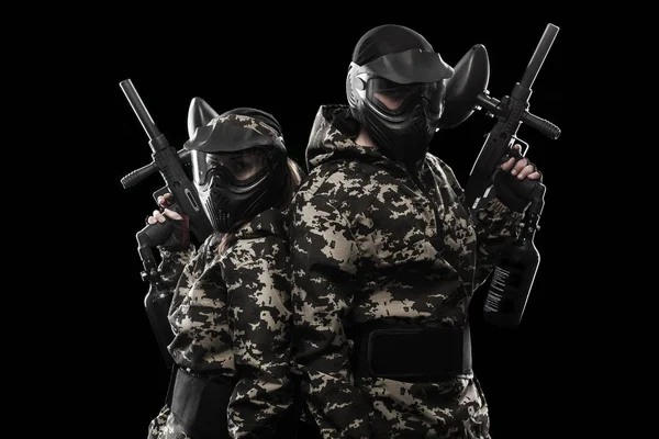 Zwaarbewapende gemaskerde paintball soldaat geïsoleerd op zwarte achtergrond. AD concept. — Stockfoto