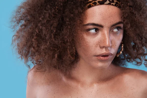 Skönhet, porträtt av flicka med afro frisyr. Flicka poserar på blå bakgrund. Studio skott. — Stockfoto