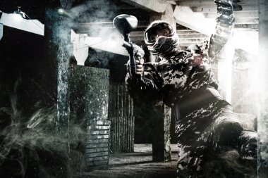 Ağır silahlı maskeli paintball asker sonrası kıyamet arka plan üzerinde. Reklam kavramı.