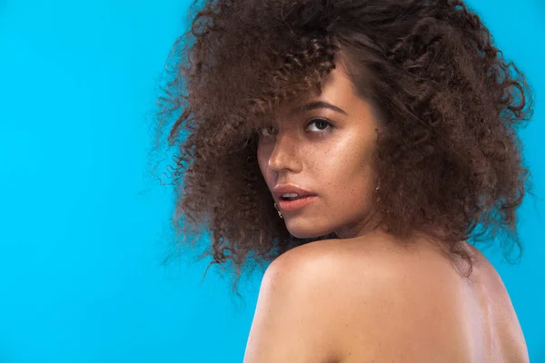 Skönhet, porträtt av flicka med afro frisyr. Flicka poserar på blå bakgrund. Studio skott. Kopiera utrymme. — Stockfoto