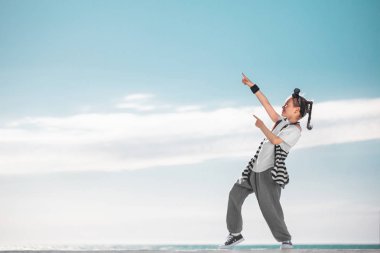 Kız çocuk kopya alanı üzerinde gökyüzü arka plan üzerinde işaret. Moda çocuk.