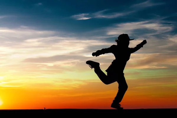 Silueta de niña bailando sobre fondo del atardecer. Niño de verano . — Foto de Stock