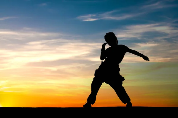 Silhouette of little girl dancing on sunset sky background — Stock Photo, Image