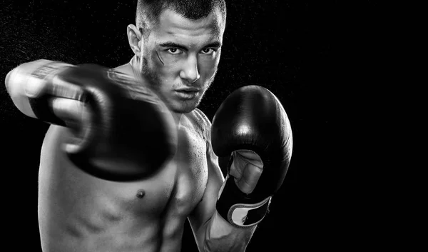 Спортсмен муай тайський боксер, що бореться в рукавичках в боксерській клітці. Ізольовано на чорному тлі з простором копіювання. Чорно-біле фото. Спортивна концепція . — стокове фото