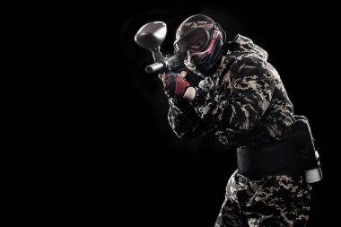 Siyah arka plan üzerine izole ağır silahlı maskeli asker. Spor Oyunları Top ve lazer etiketi boya.