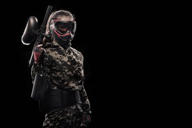 Siyah arka plan üzerine izole ağır silahlı maskeli asker. Spor Oyunları Top ve lazer etiketi boya.