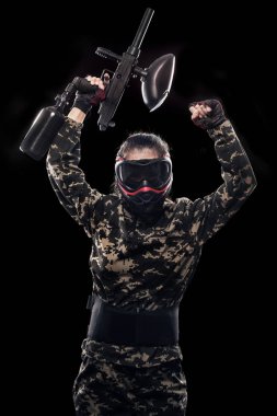 Siyah arka plan üzerine izole ağır silahlı maskeli asker. Paintball ve lasertag spor oyunları.