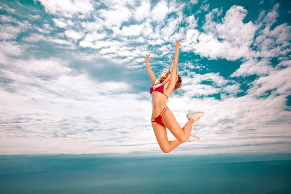 A beautiful woman jumping, over sea background at summer. Travel concept. — Stock Photo, Image