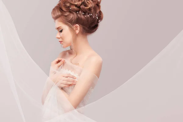 Beautiful bride with fashion wedding hairstyle - on gray background. Closeup portrait of young gorgeous bride. Wedding. Studio shot with copy space. — Stock Photo, Image