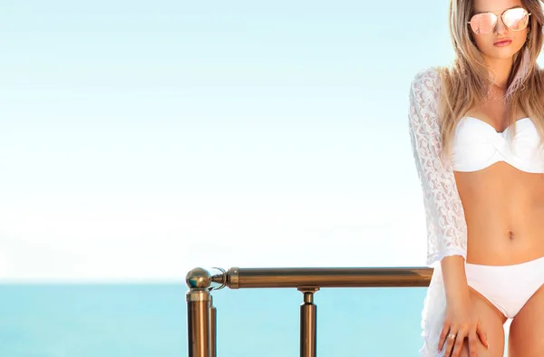 Portret van een vrouw in witte duik pak poseren op het strand — Stockfoto