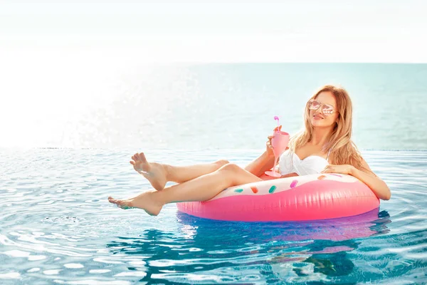 Vacaciones de verano. Mujer en bikini en el colchón inflable de la dona en la piscina SPA . — Foto de Stock