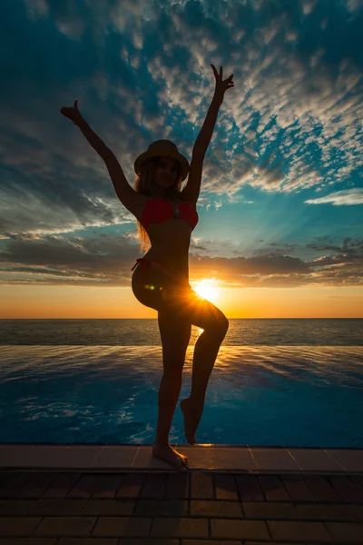 Summer Vacation. Silhouette of beauty dancing woman on sunset near the pool with ocean view. — Stock Photo, Image