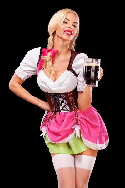 Retrato de menina Oktoberfest - garçonete, vestindo um vestido tradicional da Baviera, servindo canecas de cerveja grandes em fundo preto . — Fotografia de Stock