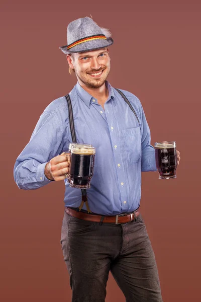Oktoberfest ember kalapban, egy hagyományos bajor ruhát visel, szolgálja a nagy söröskorsót portréja. — Stock Fotó